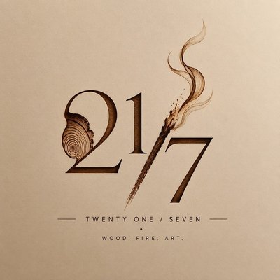 Studio 21/7 logo — the numerals 21/7 debossed into cream paper, the slash a burning match