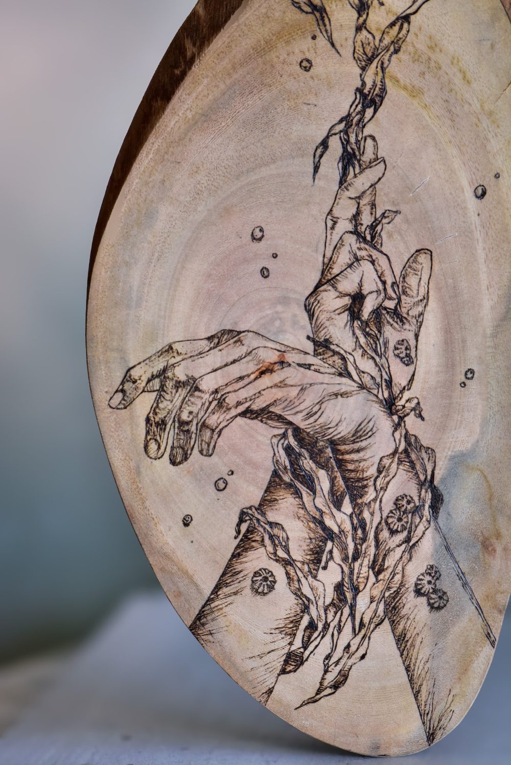 Snare — two hands entangled in kelp and barnacles among rising bubbles, burned on an oval slab