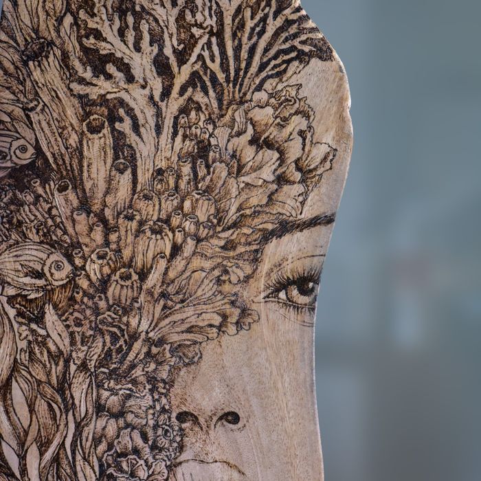 Detail of Still Becoming: burned coral and reef textures dissolving into a woman's face